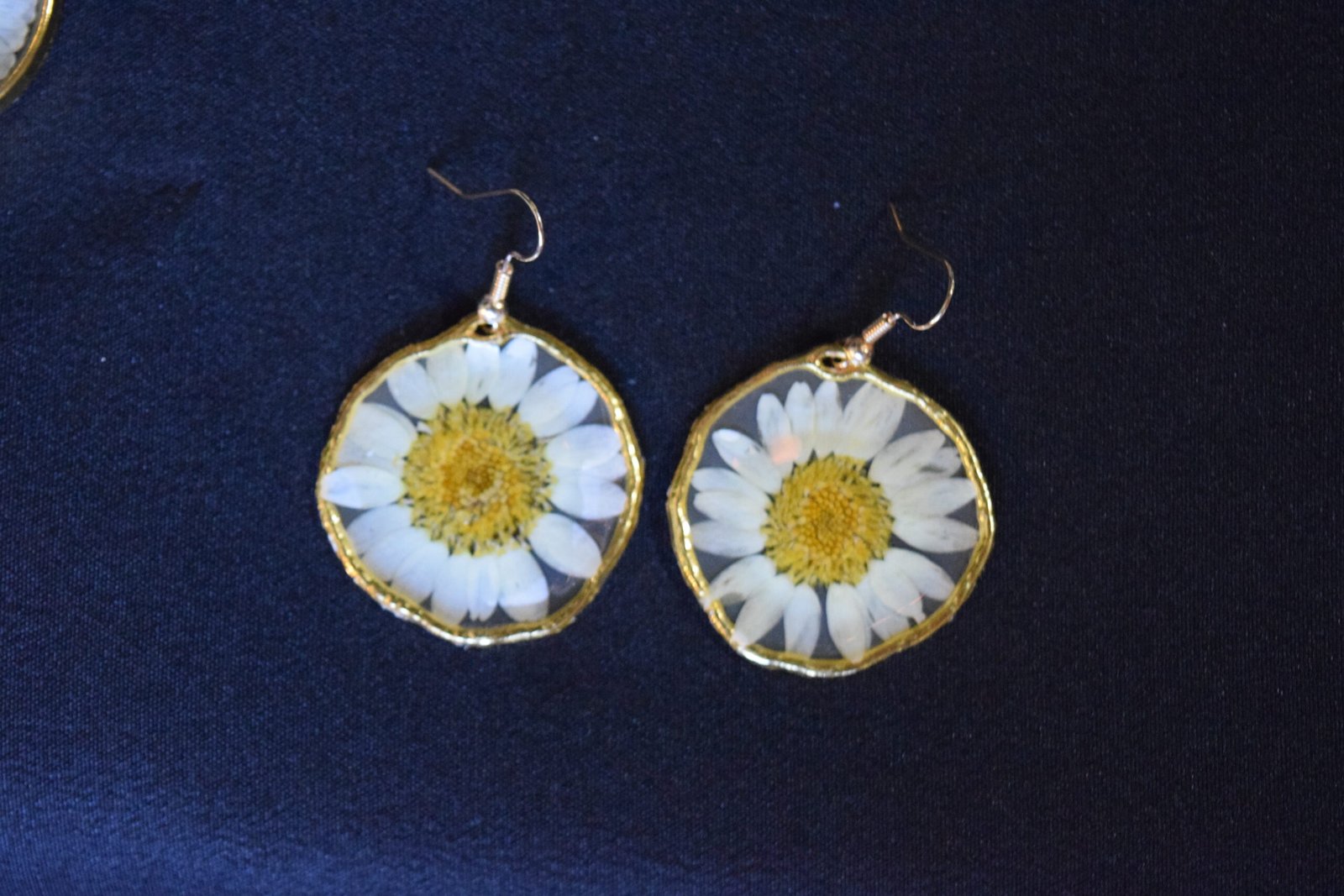 Golden round open bezel earrings with big white daisy in transparent resin